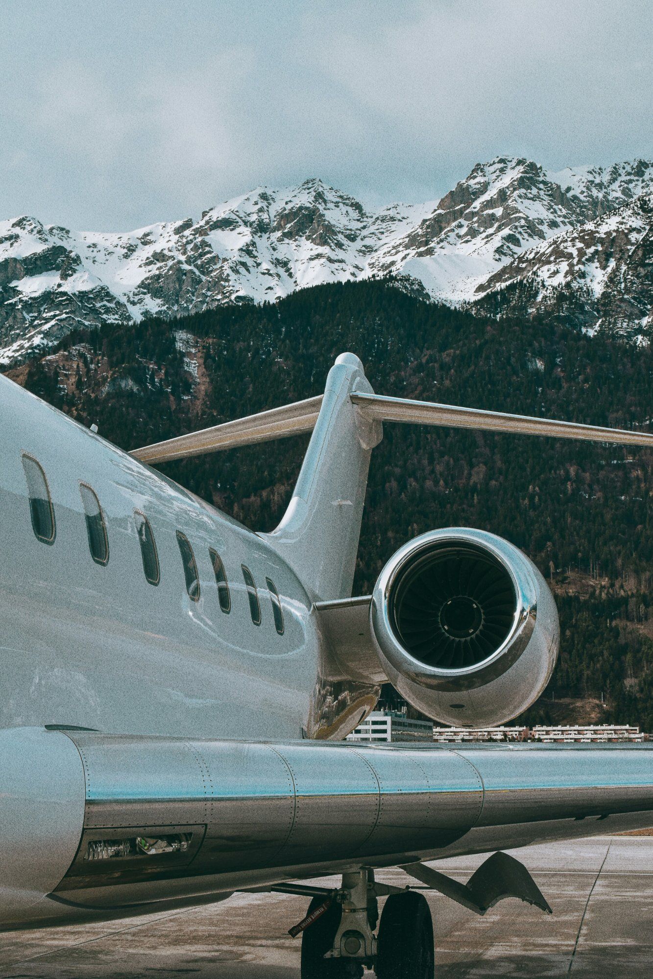 Business jet on the ramp with snow-covered mountains behind it