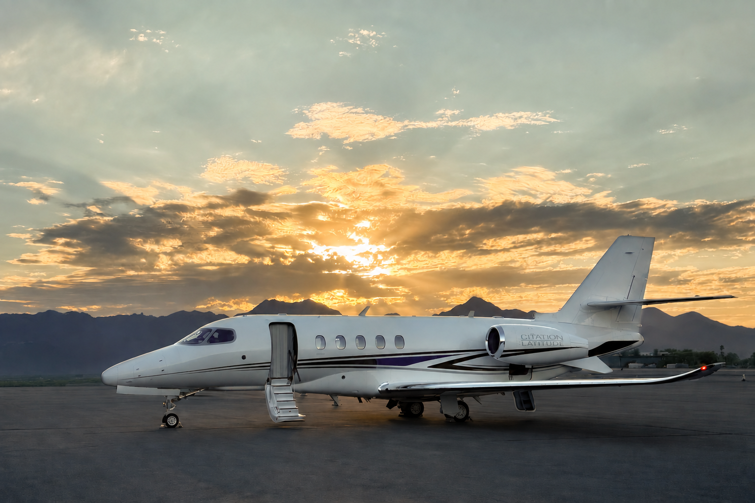 Citation Latitude business jet parked at sunset with mountains in the distance